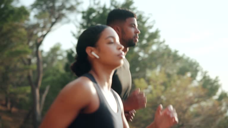 Young fit couple  running outdoors near the sea during beautiful sunrise, slow motion.