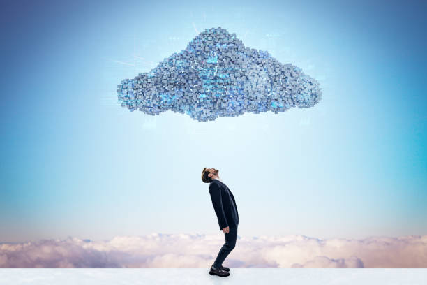 istock Side view of businessman standing under abstract digital cloud with programming language on bright sky background. Digital storage, database, network and technology concept. 2028229624