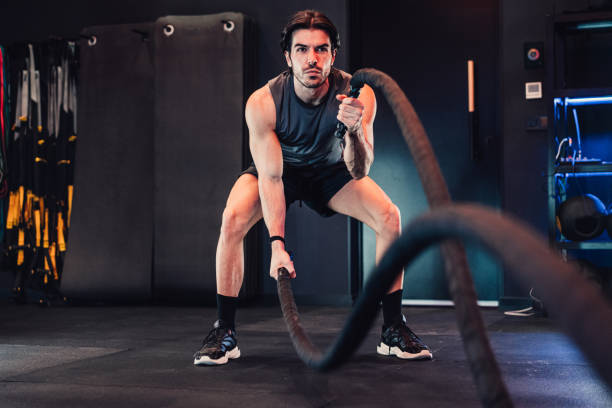 istock Young man practicing battle rope in gym. 2028231746