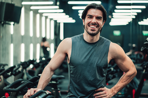 Portrait of a handsome young sporty man standing in the gym and looking at camera.