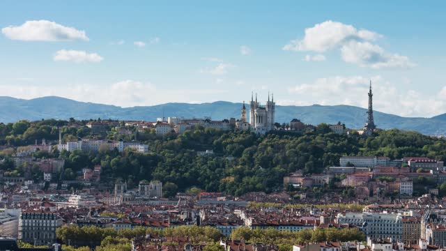 Drone timelapse of Lyon skyline revealing Basilica of Notre Dame of Fourviere under blue sky