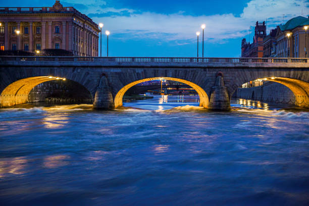 View of the underside of centralbron bridge with stockholm cityscape and riddarholmen church in the background at sunset