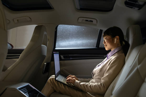 istock Rich businesswoman working on laptop computer while riding in luxurious car. 2028281415