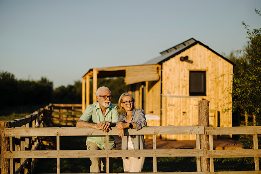 Loving senior couple standing in front of their house