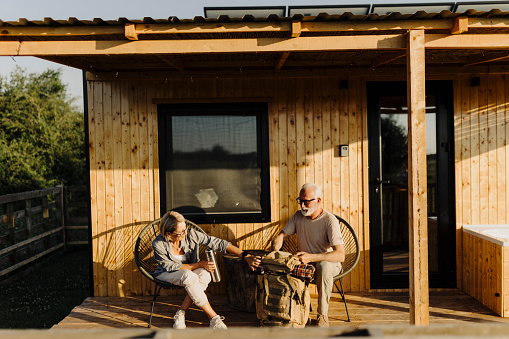 Senior couple enjoying on a patio of their glamping cabin