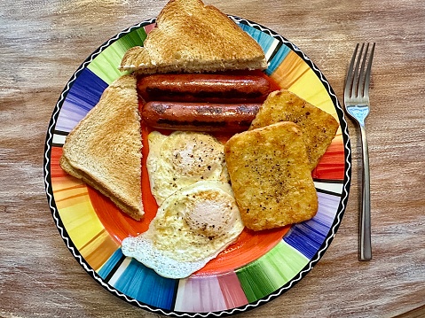 Big classic breakfast plate with fried eggs, jalapeño sausage, hash browns and toast.