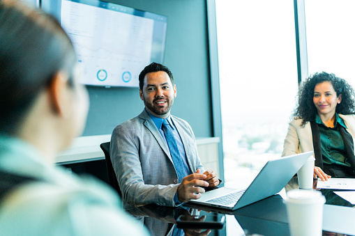 Mid adult businessman talking with coworkers on business meeting