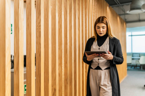istock Young businesswoman using digital tablet and walking on the office 2028310846