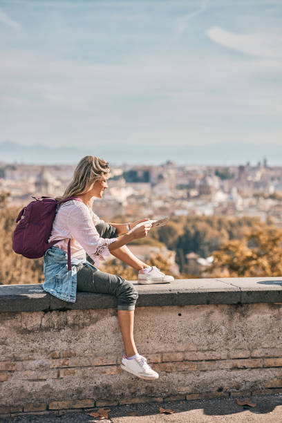 istock Young female tourist reading a map while exploring big city 2028312445