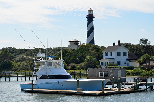 Boat at marina with the historic St. Augustine, Florida lighthouse in the background.