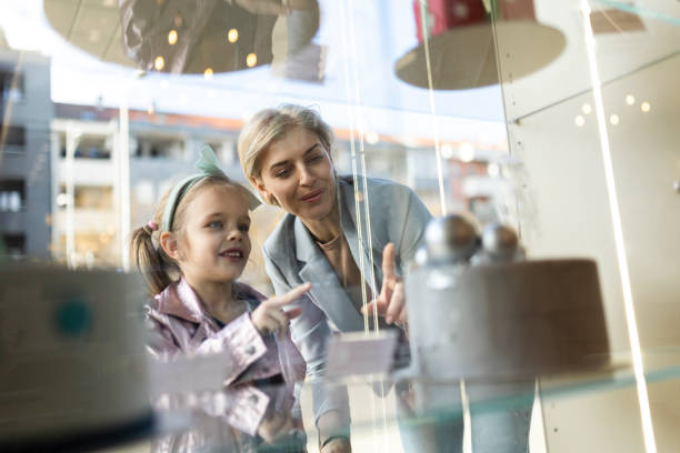 istock Mother and daughter looking at a cake store window 2028334482