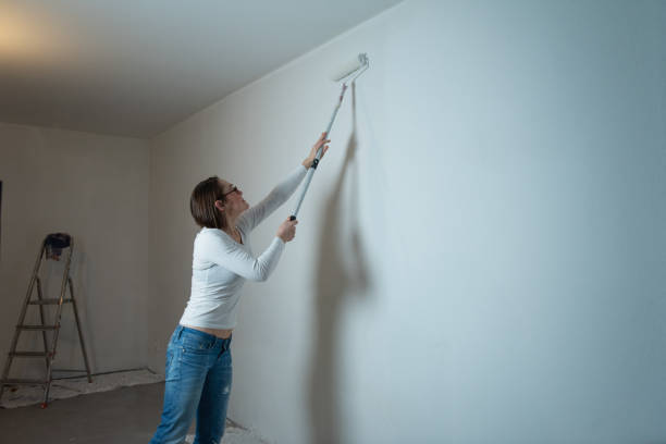 istock Young happy woman paints her apartment 2028346469