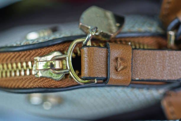 yellow metal zip on a white brown leather bag
