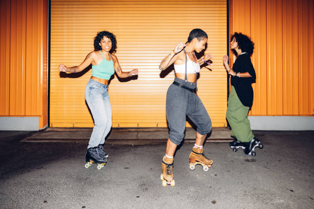 drei freestyler auf rollschuhen tanzen nachts - only women flash stock-fotos und bilder