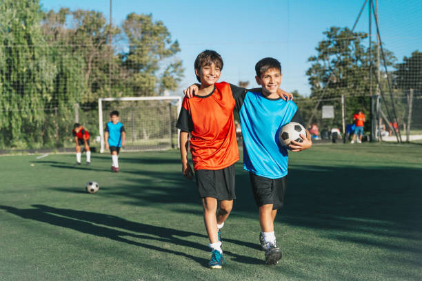 istock two boys from opponent teams walking embraced  after match 2028371699