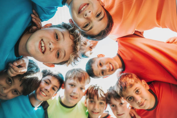 istock boy soccer team standing in circle and and looking down to camera 2028375373