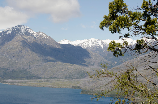 shoreline of epuyen lake in argentine patagonia with mountains in the background.