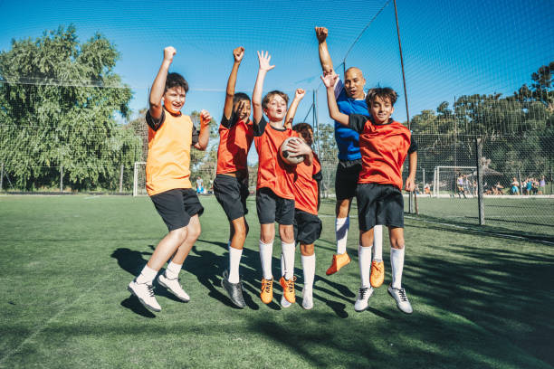 istock young soccer team celebrating with coach 2028376411