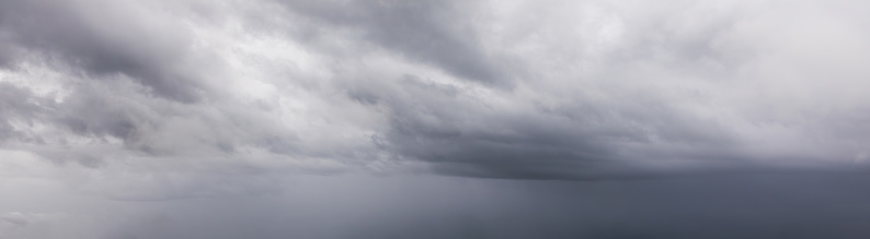 Panoramic view of the raw power of nature as storm clouds gather ominously in the sky, heralding the arrival of rain. Dark and brooding, these clouds promise a deluge, casting a dramatic and foreboding atmosphere over the landscape. As the air crackles with anticipation, the impending storm serves as a reminder of nature's awe-inspiring might and beauty.