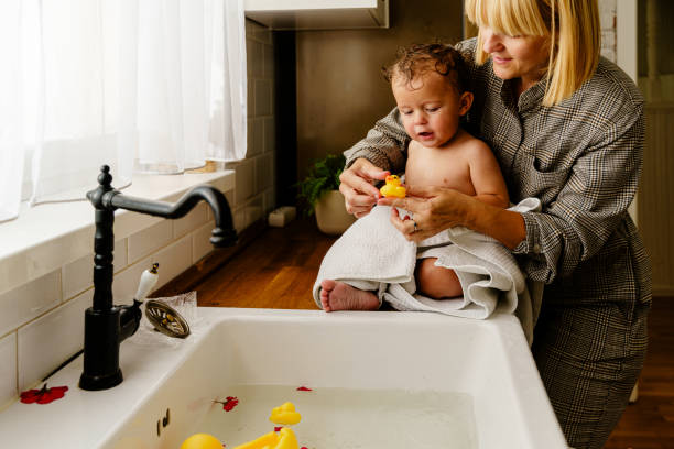 istock Baby boy playing with live birth duck in the kitchen sink 2028436009