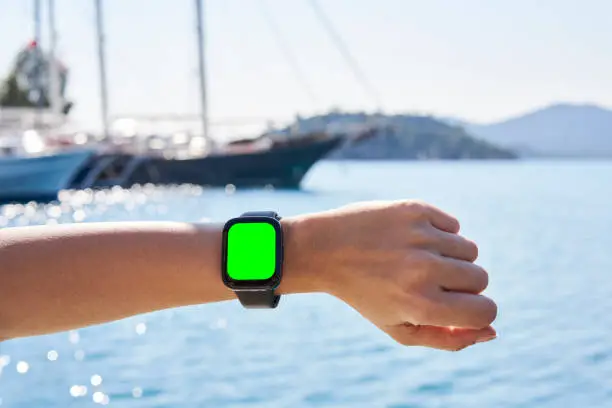 Vector illustration of Hand wearing smart watch on blurred Sea background. wearable gadget concept