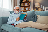Happy senior man relaxing on sofa at home