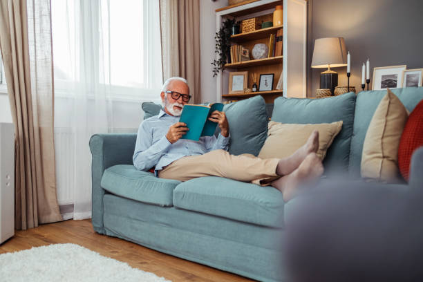 istock Happy senior man relaxing on sofa at home 2028464433