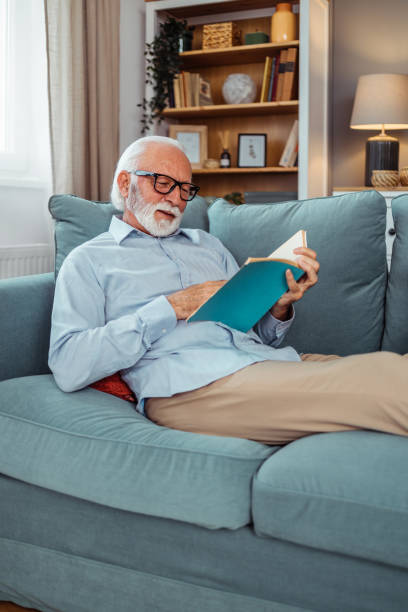 istock Happy senior man relaxing on sofa at home 2028464492