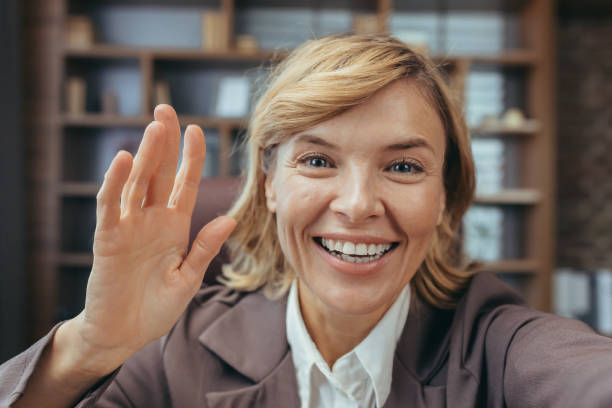 istock Confident mature businesswoman giving a friendly wave in home office setting 2028470381