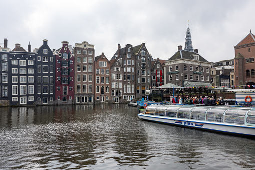 Amsterdam, Netherlands - April 21, 2023: Typical gabled houses on Damrak district in  Amsterdam, Netherlands