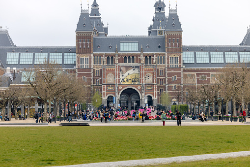 Amsterdam, Netherlands - April 21, 2023: Facade of the Rijksmuseum Dutch national museum with a banner advertising a special exhibition of Vermeers paintings