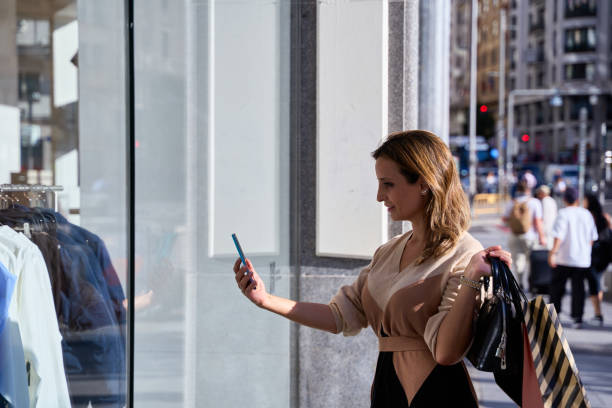 istock young woman taking a photo through a store window 2028493054