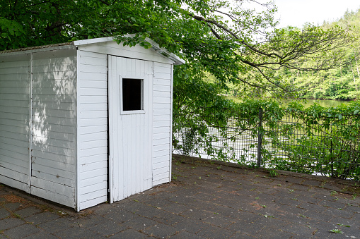 Small white tool shed by the lake