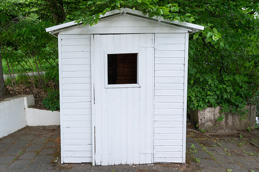 Small white tool shed in the park