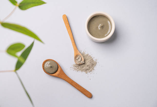 istock Blue clay in a bowl and spoons on a light background with branch. 2028536974