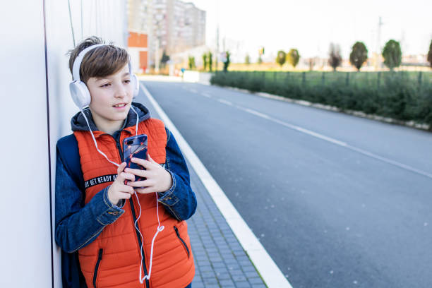istock Schoolboy with headphones is going home after school. 2028545411