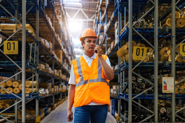 istock Warehouse worker in protective helmet talking on walkie talkie 2028554341