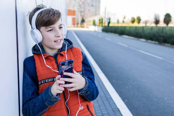 istock Schoolboy with headphones is going home after school. 2028567480
