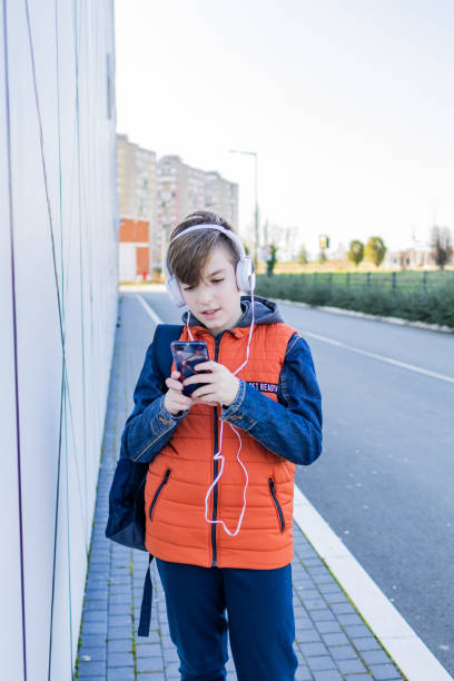 istock Schoolboy with headphones is going home after school. 2028571659