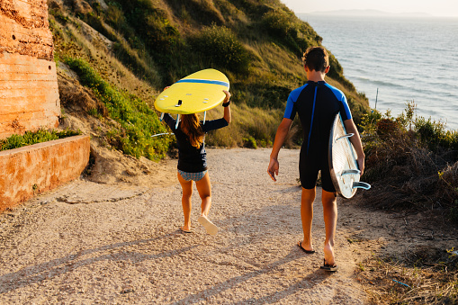 Young teenagers preparing for taking a surf on the beach