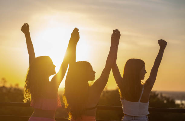 istock girls at sunset raised their hands 2028640211