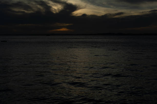 Dramatic sunset with dark clouds and sun in yellow color. City of Salvador, Bahia.