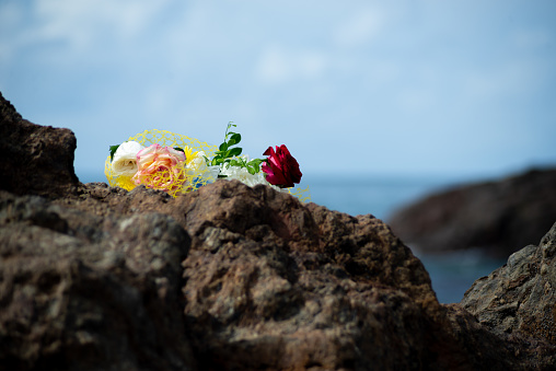 Flowers on top of a beach rock. Tribute to iemanja.