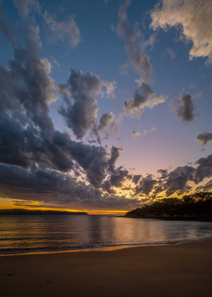 Smooth Sunrise Seascape with interesting clouds in the sky at Pearl Beach on the Central Coast, NSW, Australia.