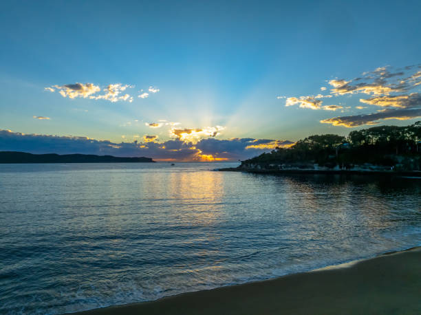 Smooth Sunrise Seascape with interesting clouds in the sky at Pearl Beach on the Central Coast, NSW, Australia.