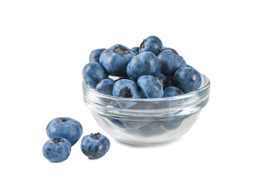 Fresh blueberries in small transparent bowl isolated on white background with copy space. Organic berries, healthy food, wild berries