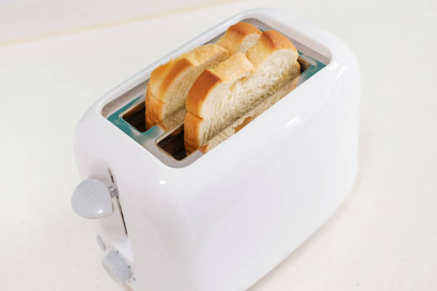 istock Pieces of bread in a toaster on white background, side view. 2028823574