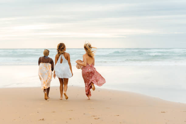 istock girls walking along the seashore 2028825652