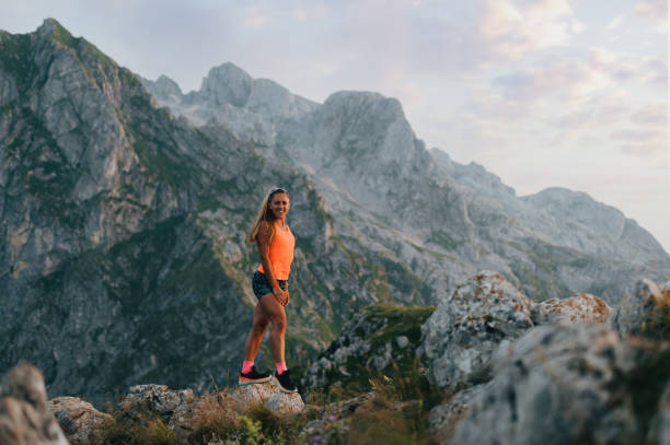 istock A skyrunner is standing on rock in mountains and smiling at the camera. 2028853887