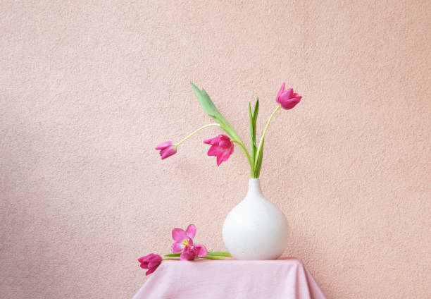 istock tulips in vase on table on background wall 2028858971